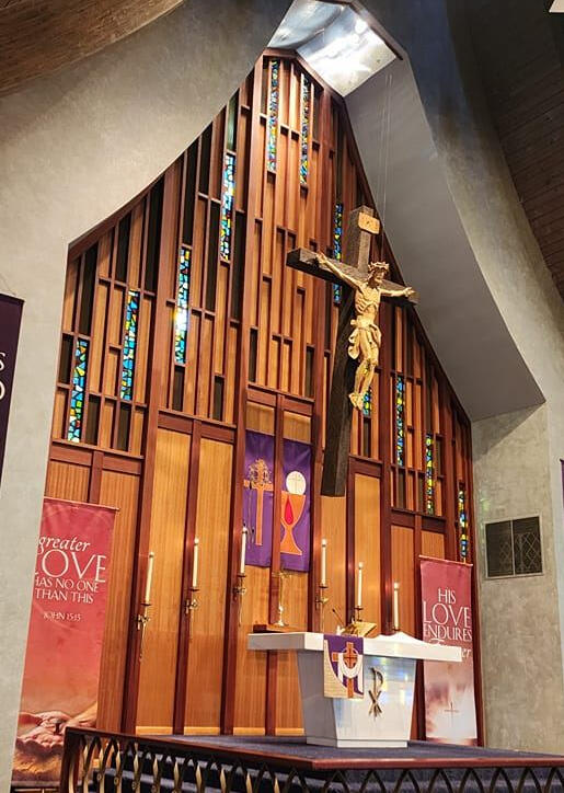 Hmong Hope Lutheran sanctuary in Milwaukee with crucifix, stained glass, and purple Lenten banners behind the altar.